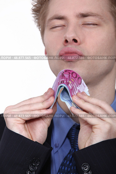 young man holding bank notes. Стоковое фото, агентство Ingram Publishing / Фотобанк Лори