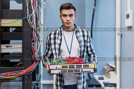 young man holding ethernet switches wires. Стоковое фото, агентство Ingram Publishing / Фотобанк Лори