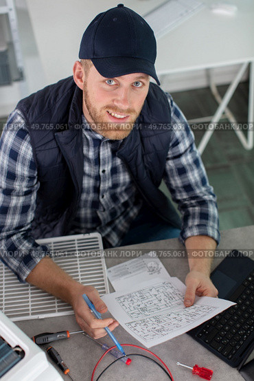 young man installing device reading manual. Стоковое фото, агентство Ingram Publishing / Фотобанк Лори