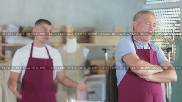 Young man scolding elderly man in sewing workshop. Стоковое видео, видеограф Яков Филимонов / Фотобанк Лори