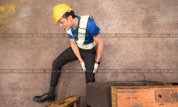 Young man working in a steel industry factory. He was critically hurt when a forklift ran over his leg and had to be transported to the hospital. Стоковое фото, агентство Ingram Publishing / Фотобанк Лори