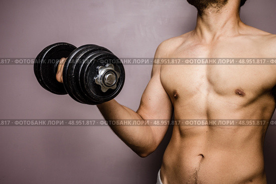 Young man working out with a dumbbell. Стоковое фото, агентство Ingram Publishing / Фотобанк Лори