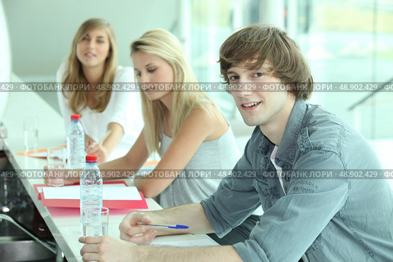 Young people in a bar with coursework and bottles of water. Стоковое фото, агентство Ingram Publishing / Фотобанк Лори