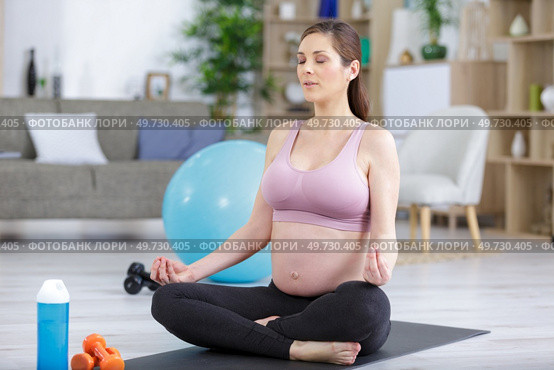 young pregnant woman meditating in lotus position. Стоковое фото, агентство Ingram Publishing / Фотобанк Лори