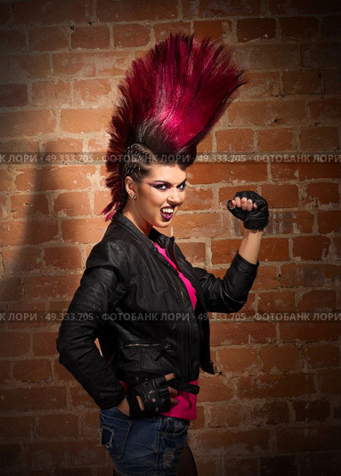 Young punk girl on brick wall background. Стоковое фото, агентство Ingram Publishing / Фотобанк Лори