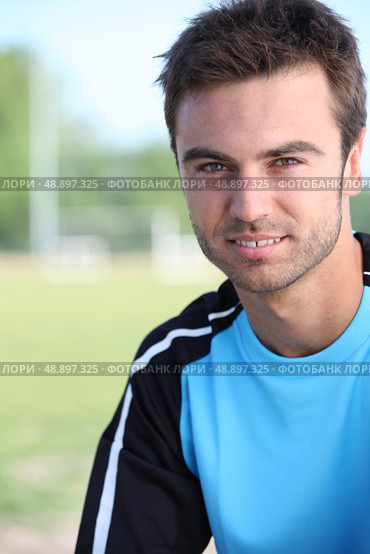 Young soccer player stood by pitch. Стоковое фото, агентство Ingram Publishing / Фотобанк Лори