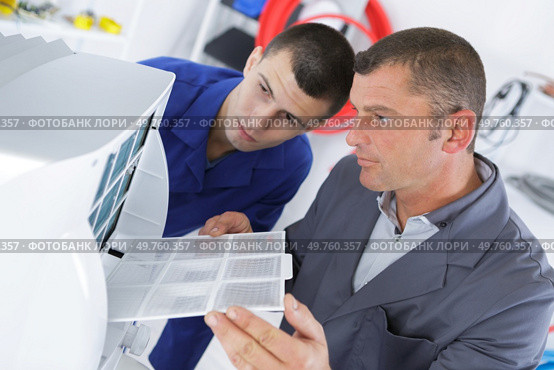 young technician apprentice repairing ac with teacher. Стоковое фото, агентство Ingram Publishing / Фотобанк Лори