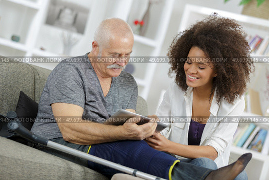 young woman and senior man chating with family using tablet. Стоковое фото, агентство Ingram Publishing / Фотобанк Лори