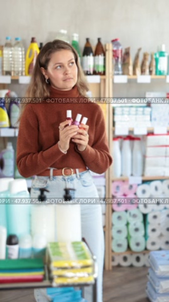 Young woman buyer chooses nail polish in household chemicals store. Стоковое видео, видеограф Яков Филимонов / Фотобанк Лори