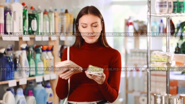 Young woman choosing a set of plastic and wooden clothespins for laundry in a household store. Стоковое видео, видеограф Яков Филимонов / Фотобанк Лори