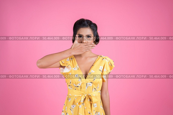 Young woman covering her mouth showing shut up. Стоковое фото, агентство Ingram Publishing / Фотобанк Лори