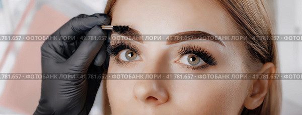 Young woman face during professional eyebrow mapping procedure before permanent makeup and lamination. Artist does long-lasting styling of the eyebrows with hair coloring. Panorama with copy space. Стоковое AI-изображение, AI-художник Igor Tichonow / Фотобанк Лори