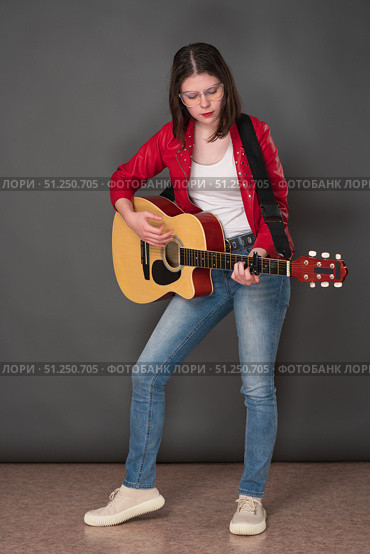 Young woman guitarist playing six string acoustic guitar, standing full length on stage. Стоковое фото, фотограф А. А. Пирагис / Фотобанк Лори
