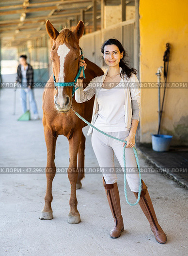 Young woman leads horse out of stable. Стоковое фото, фотограф Яков Филимонов / Фотобанк Лори