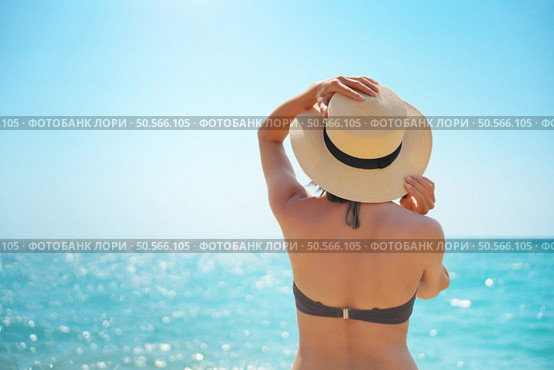 Young woman looking on the sea in hat at day. Relax and nature scene. Стоковое фото, агентство Ingram Publishing / Фотобанк Лори