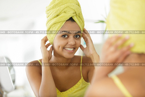 young woman looks at herself in the mirror. Стоковое фото, агентство Ingram Publishing / Фотобанк Лори