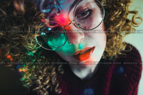 Young woman portrait illuminated by psychedelic lights. Стоковое фото, агентство Ingram Publishing / Фотобанк Лори