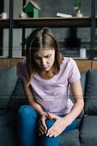 young woman suffering from knee pain. Стоковое фото, агентство Ingram Publishing / Фотобанк Лори