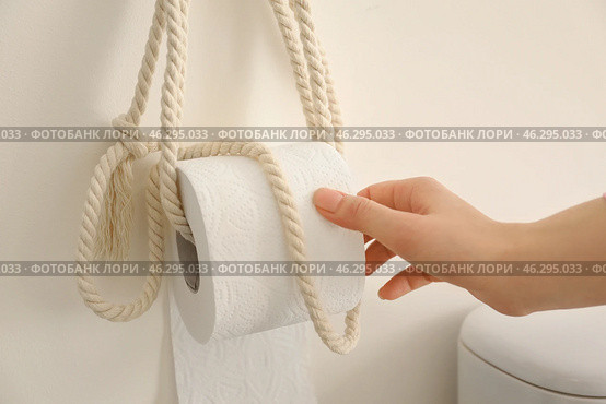 Young woman taking soft toilet paper in restroom. Стоковое фото, фотограф Pixel_shot / Фотобанк Лори