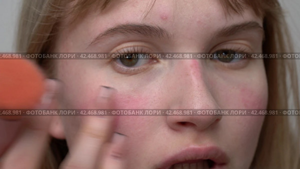 Young woman uses her finger to blend blush. Process applying blush to face with makeup brush. Стоковое видео, видеограф А. А. Пирагис / Фотобанк Лори