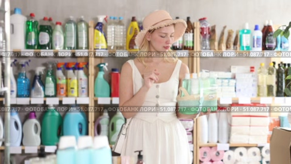 Young woman view trademark sign on label, chooses eco friendly present bath cosmetic kit. Стоковое видео, видеограф Яков Филимонов / Фотобанк Лори