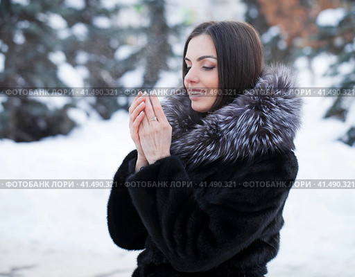 Young woman warms her palms with her breath in the frosty weather of her palms. Стоковое фото, фотограф Андрей Аркуша / Фотобанк Лори