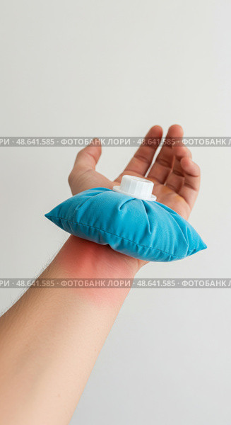 Запястье с покраснением, к которому приложен холодный компресс. Процедура, символизирующая облегчение боли и лечение травмы или отека. Редакционное AI-изображение, AI-художник Ирина Першина / Фотобанк Лори