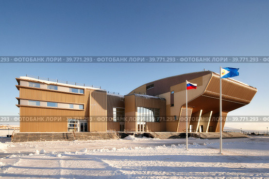 Здание Музейного центра "Наследие Чукотки" и Чукотского окружного дома народного творчества, Анадырь, Чукотка, Россия. На центральной площади установлены флаги России и Чукотки. Крайний Север, Арктика. Редакционное фото, фотограф Андрей Степанов / Фотобанк Лори