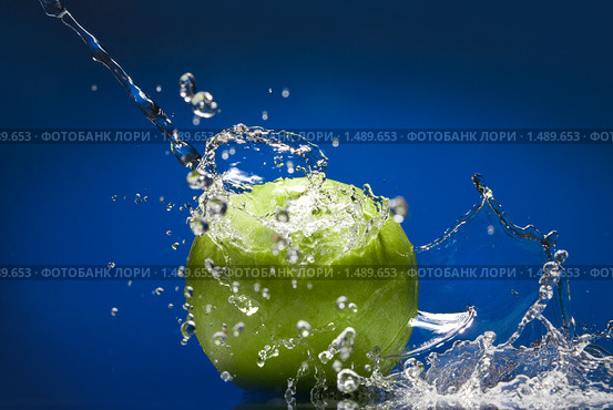 Зеленое яблоко с всплеском воды на синем фоне. Стоковое фото, фотограф Ярослав Данильченко / Фотобанк Лори