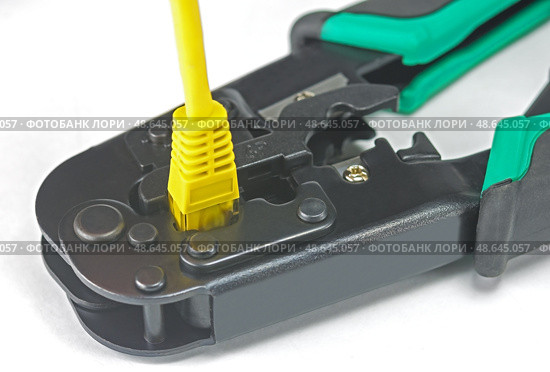 Желтый LAN кабель и инструмент обжимки кабелей на белом фоне. LAN cable and cable crimping tool on white background. Стоковое фото, фотограф Татьяна Д / Фотобанк Лори