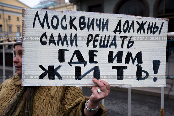 Женщина держит плакат против сноса пятиэтажных домов с надписью "Москвичи должны сами решать где им жить!" на митинге КПРФ на площади Революции в центре города Москвы, Россия (2017 год). Редакционное фото, фотограф Николай Винокуров / Фотобанк Лори