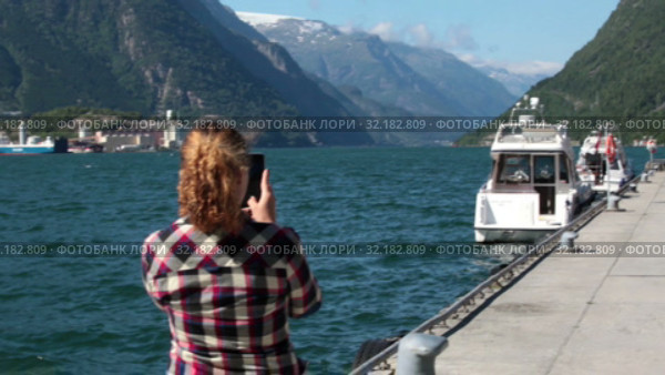Женщина фотографирует фьорд на камеру смартфона. Одда, Норвегия (2019 год). Стоковое видео, видеограф Кекяляйнен Андрей / Фотобанк Лори