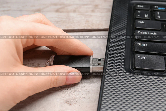 Женщина использует черный USB-накопитель с современным ноутбуком на белом деревянном фоне. Стоковое фото, фотограф Pixel_shot / Фотобанк Лори