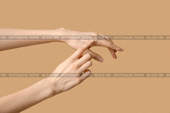 Женщина наносит тональный крем на коричневом фоне. Стоковое фото, фотограф Pixel_shot / Фотобанк Лори