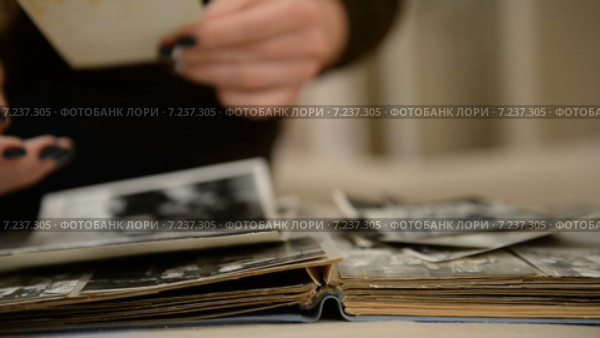 Женщина смотрит старый фотоальбом. Стоковое видео, видеограф Mikhail Erguine / Фотобанк Лори