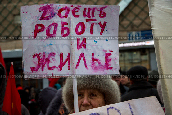 Женщинаидет на шествии КПРФ с плакатом "Даешь работу и жилье" в центре города Москвы, Россия (2016 год). Редакционное фото, фотограф Николай Винокуров / Фотобанк Лори