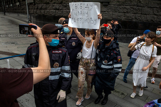 Женщину с плакатом "Свободу Ивану Сафронову" в поддержку журналиста Ивана Сафронова задерживают сотрудники полиции во время одиночного пикета у здания ФСБ в центре города Москвы, Россия (2020 год). Редакционное фото, фотограф Николай Винокуров / Фотобанк Лори