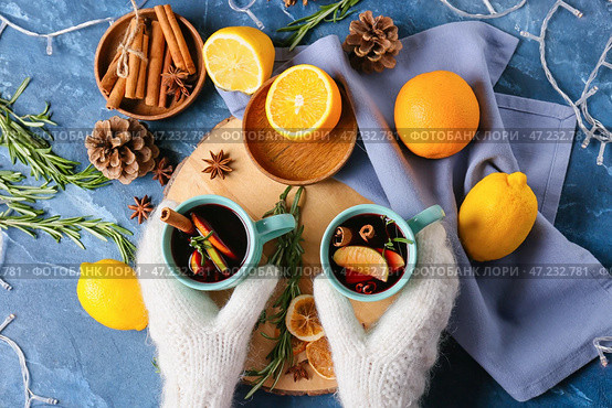 Женские руки с чашками вкусного глинтвейна на цветном фоне. Стоковое фото, фотограф Pixel_shot / Фотобанк Лори