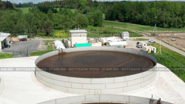 Животноводческая ферма. Резервуары с навозом и станция по выработке метана. Вид с воздуха. Livestock farm. Manure tanks and a methane production plant. Aerial view. (2022 год). Редакционное видео, видеограф Евгений Романов / Фотобанк Лори