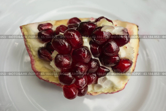 Зрелый гранат с зернами крупным планом на белом фоне/ Ripe pomegranate fruit segment isolated on white background. Стоковое фото, фотограф Iva Noel / Фотобанк Лори